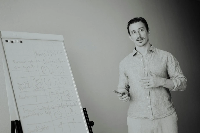 Man presenting at a whiteboard in a meeting.